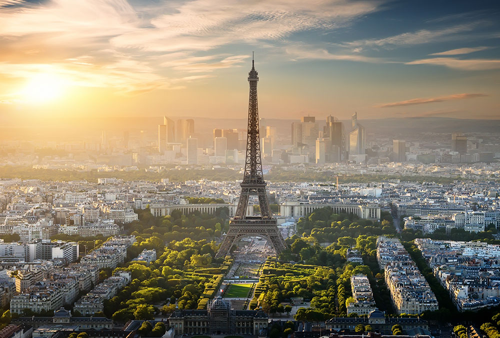 Vue de la Tour Eiffel illuminée de nuit, dominant le ciel parisien.