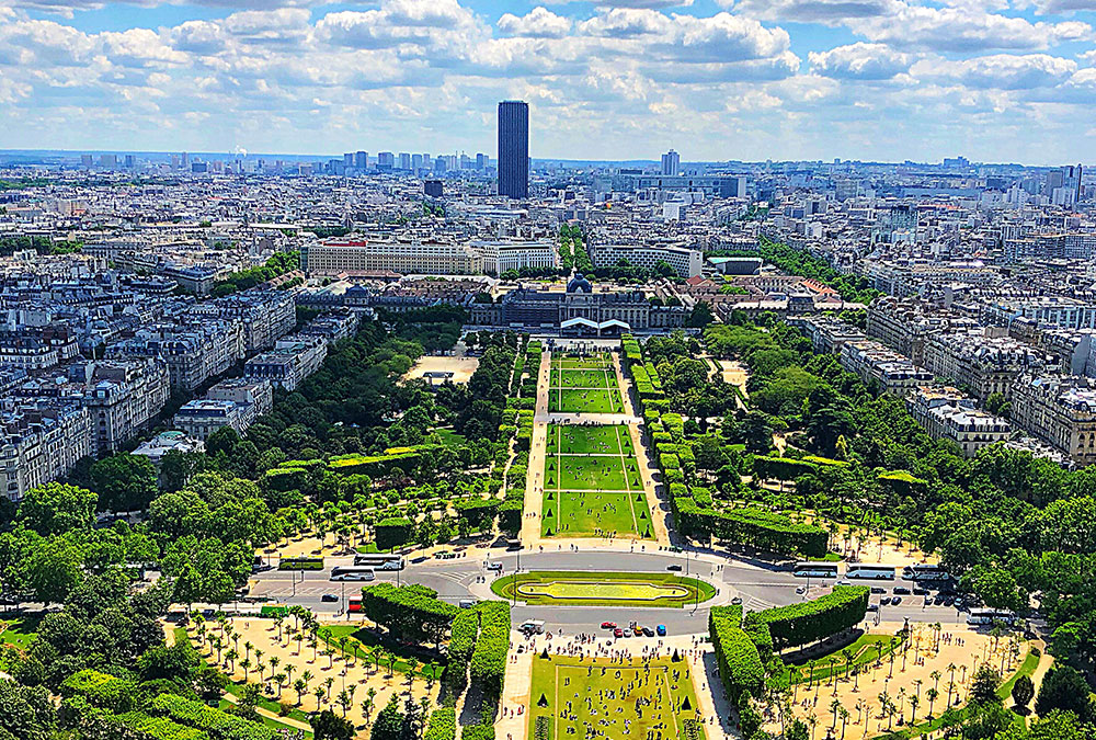 Vue du Champ de Mars avec la Tour Eiffel en arrière-plan, par un jour ensoleillé.