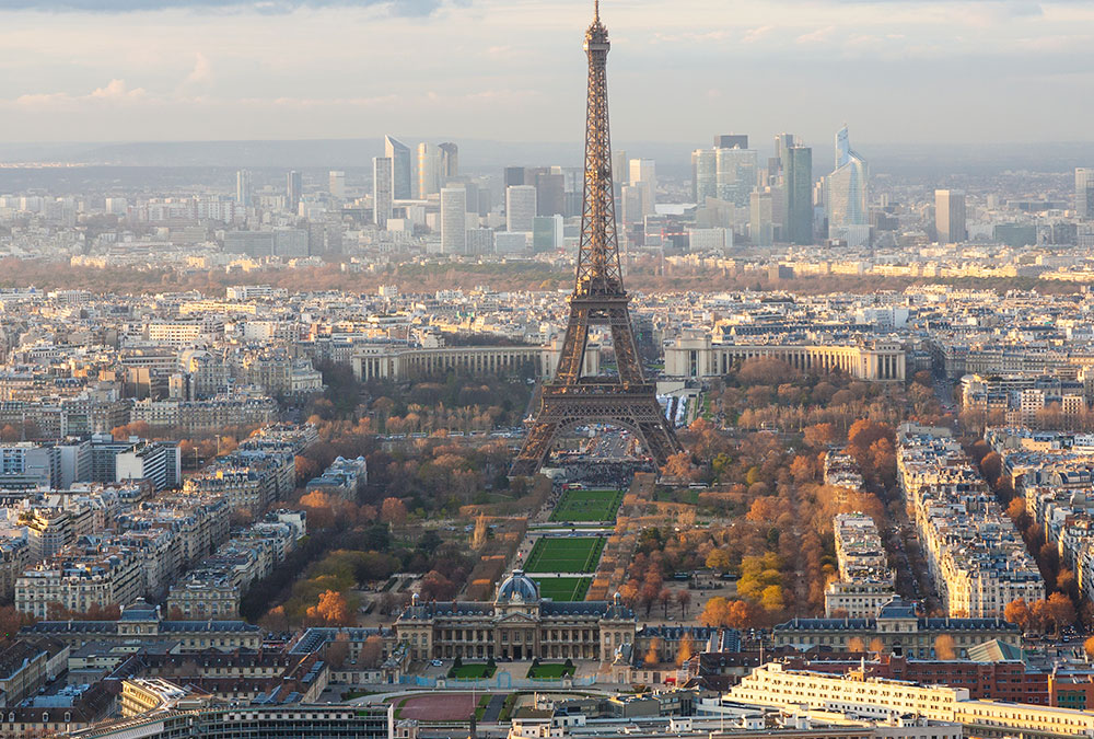 Promenade dans les jardins bien entretenus du Champ de Mars, avec des visiteurs profitant du parc.