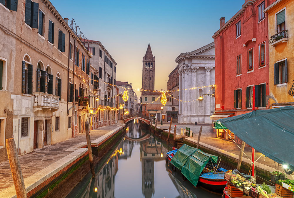 Pont de Rialto à Venise avec des gondoliers naviguant sur le Grand Canal.